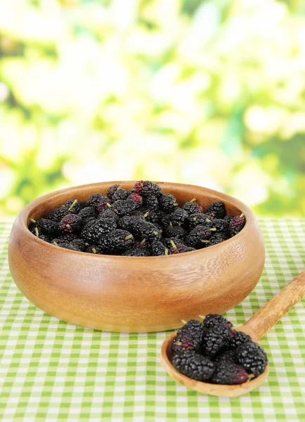 Moras maduras en tazón sobre mesa sobre fondo brillante —  Fotos de Stock