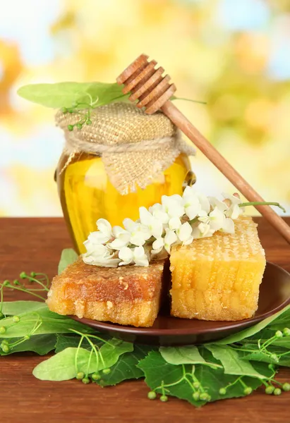 Яр з меду з квітами лайма і акації, на дерев'яному столі на яскравому фоні — стокове фото