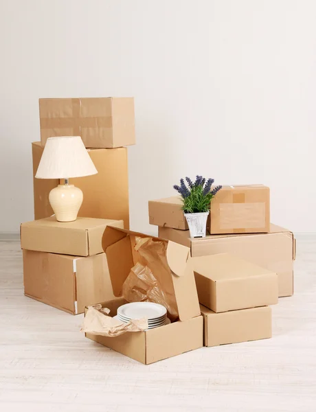 Stěhovací krabice na podlaze v prázdné místnosti — Stock fotografie