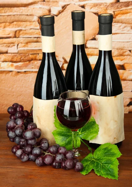 Composition of wine bottles, glass and grape, on stone background — Stock Photo, Image