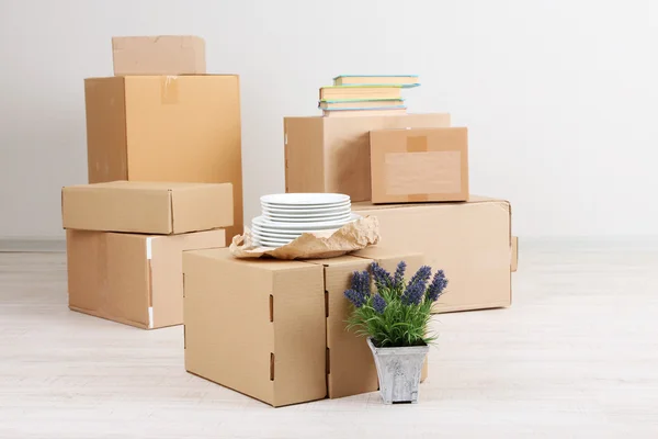 Moving boxes on the floor in empty room — Stock Photo, Image