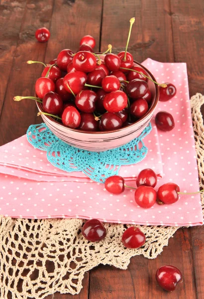 Ripe red cherry berries in bowl on wooden table close-up — Stock Photo, Image