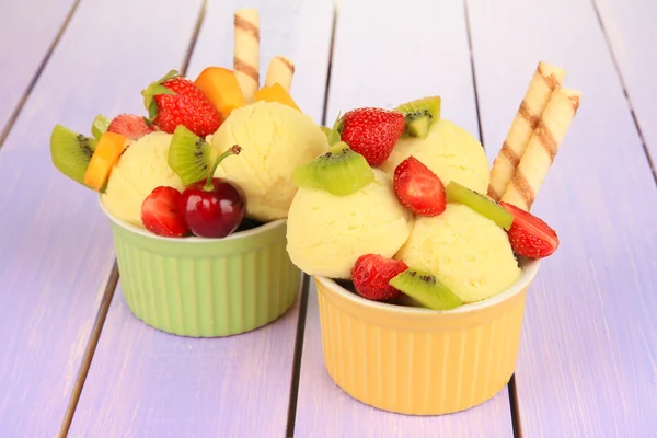 Delicioso sorvete com frutas e bagas em tigela na mesa de madeira — Fotografia de Stock