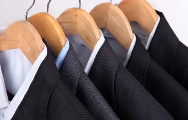 takım elbise askıları üstünde açık renkli gömlek