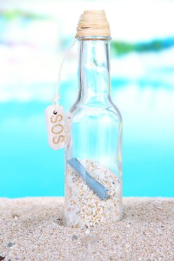 cam şişe içinde not parlak mavi arka plan ile