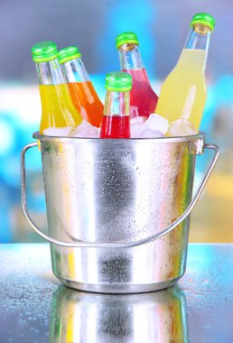 kova içinde parlak geçmiş buz küpleri ile lezzetli içecekler şişe