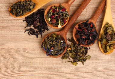 farklı türlerdeki yeşil ve siyah çay kaşığı ahşap masa üstünde kuru