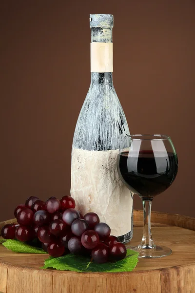 Composición con botella vieja de vino y copa de vino en bodega vieja, sobre fondo marrón oscuro — Foto de Stock