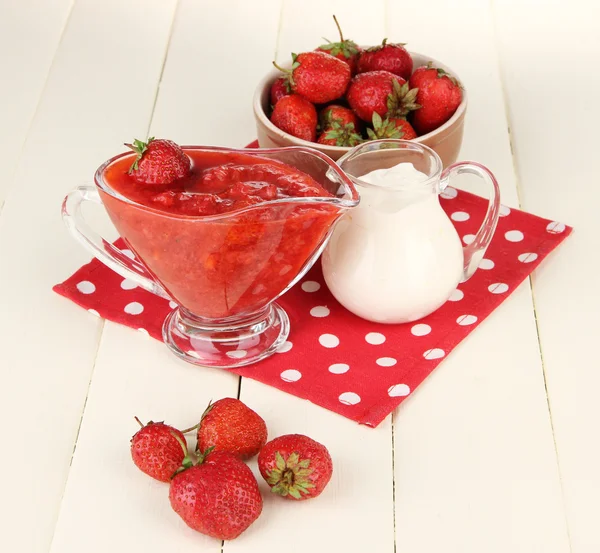 Homemade strawberry jam, on napkin, on color wooden background — Stock Photo, Image