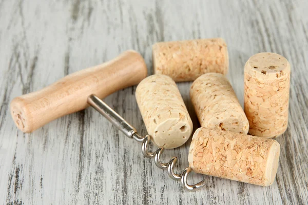 Corkscrew with wine corks on wooden table close-up — Stock Photo, Image