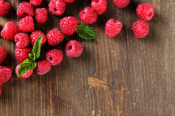 Framboises sucrées mûres sur fond de bois — Photo