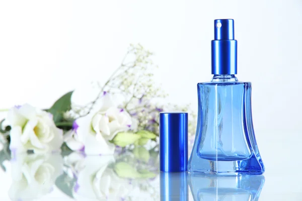 Parfüm şişesi ve üzerinde beyaz izole çiçekler — Stok fotoğraf