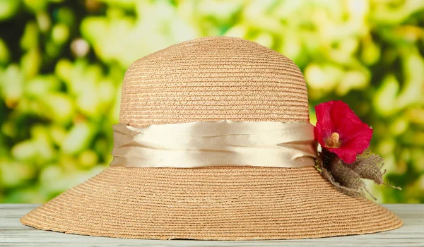 Krásné letní čepice s kytkou na zeleném pozadí — Stock fotografie
