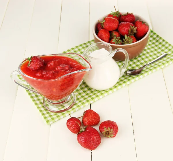 Homemade strawberry jam, on napkin, on color wooden background — Stock Photo, Image