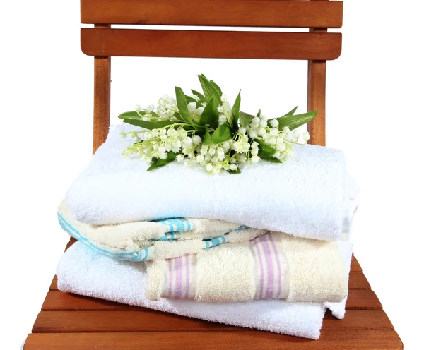 Towels and flowers on wooden chair isolated on white — Stock Photo, Image