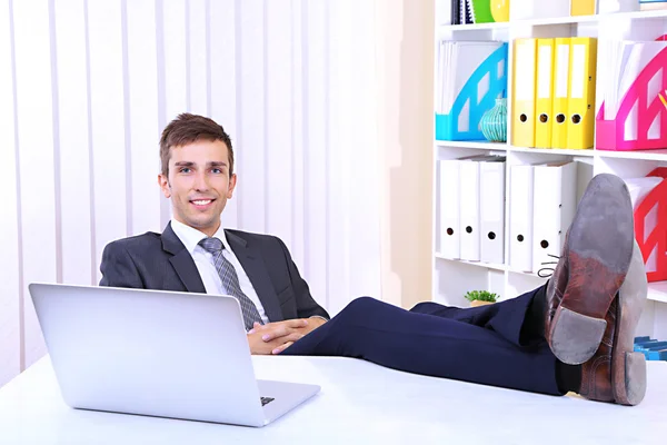 Zakenman rusten op zijn kantoor met zijn schoenen op tafel — Stockfoto