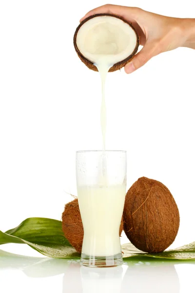 Mano de la mujer vertiendo leche de coco en un vaso sobre fondo blanco — Foto de Stock