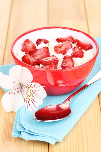 Queso de cabaña en tazón rojo con fresas en rodajas en la mesa de madera —  Fotos de Stock