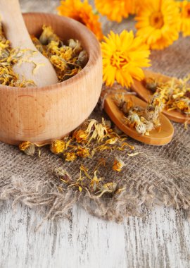 harç ahşap zemin üzerine calendula taze ve kuru çiçekler