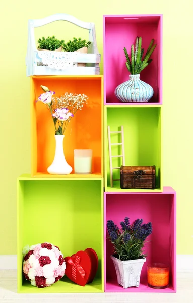 Estantes de diferentes colores brillantes con adición decorativa en el fondo de la pared — Foto de Stock