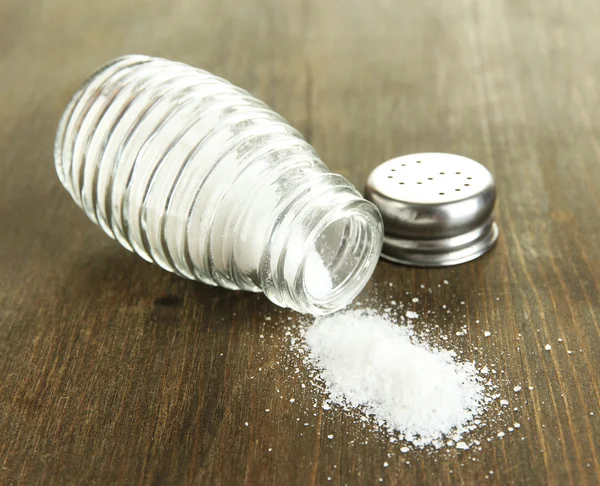 Glas saltkar med salt på trä bakgrund — Stockfoto