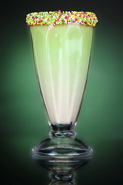 Delizioso frullato di latte su sfondo verde scuro — Foto Stock