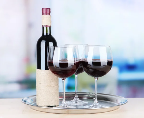 Wine glasses and bottle on bright background — Stock Photo, Image