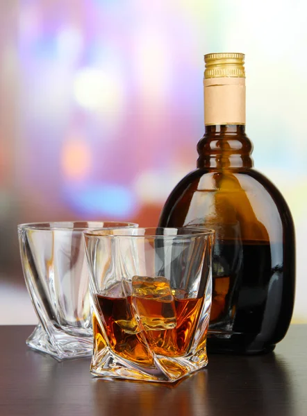 Glass of liquor with bottle, on dark background — Stock Photo, Image