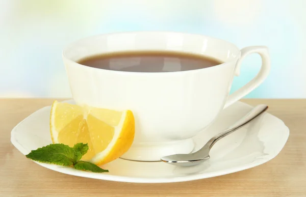 Tasse Tee mit Zitrone auf dem Tisch auf hellem Hintergrund — Stockfoto