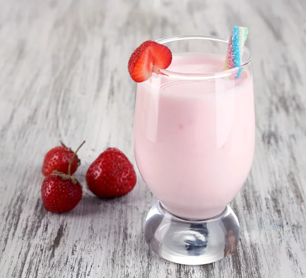 Delicious milk shake with strawberries on wooden table close-up — Stock Photo, Image