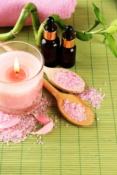 Beautiful spa setting with pink candle on bamboo mat — Stock Photo, Image