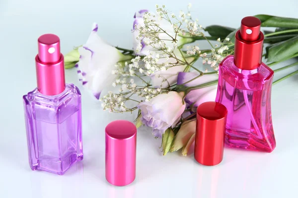 Perfume en botellas y flores aisladas en blanco — Foto de Stock