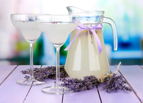 薰衣草柠檬水在玻璃壶和鸡尾酒的眼镜，在明亮的背景上 — 图库照片