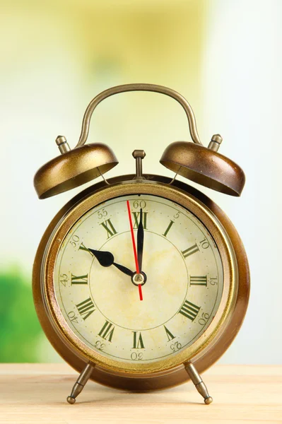 Old alarm clock on bright background — Stock Photo, Image