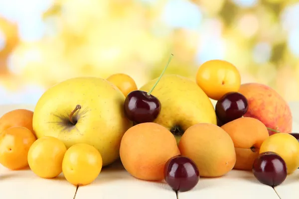 Luminosi frutti estivi su tavolo di legno su sfondo naturale — Foto Stock