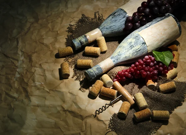 Viejas botellas de vino, uvas y corchos sobre papel viejo —  Fotos de Stock