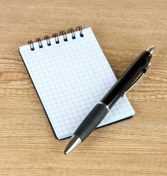 Anteckningsbok och penna på träbord — Stockfoto