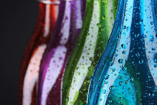 Botellas de colores sobre fondo negro — Foto de Stock