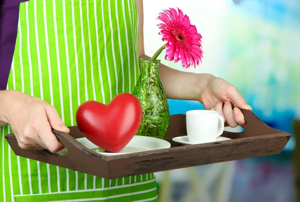 木製トレイ、朝食、明るい背景上に保持している緑のエプロンの女 — ストック写真