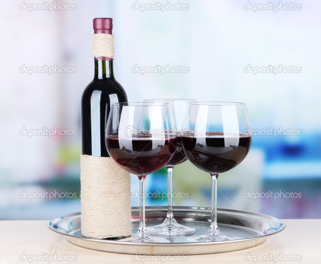 Wine glasses and bottle on bright background