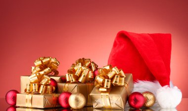 güzel Noel şapka, hediye ve kırmızı bir arka plan üzerinde Noel topları