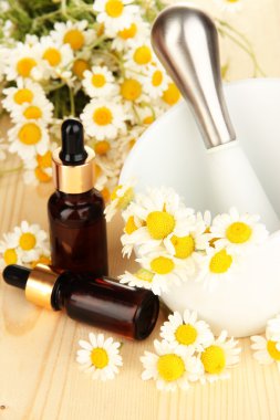 esans ve harç ahşap masa üzerinde papatya çiçeği.