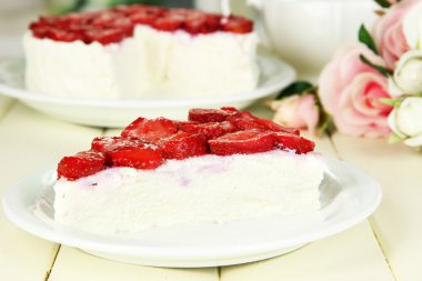 Cheesecake ahşap masa üzerinde beyaz tabak taze çilek ile