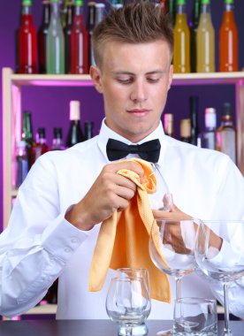 Barmen gözlük iş yerinde siliyor.