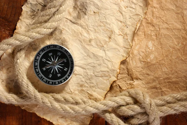 Old paper, compass and rope on a wooden table — Stock Photo, Image