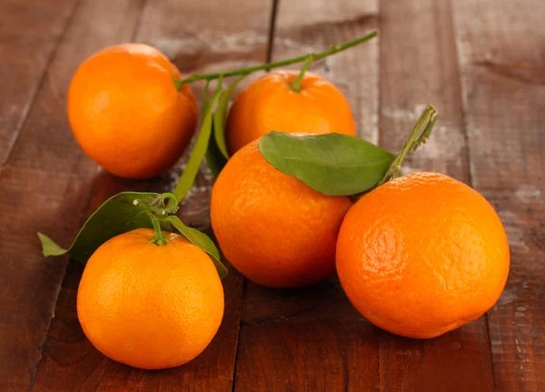 Tangerinas doces com folhas, em fundo de madeira — Fotografia de Stock