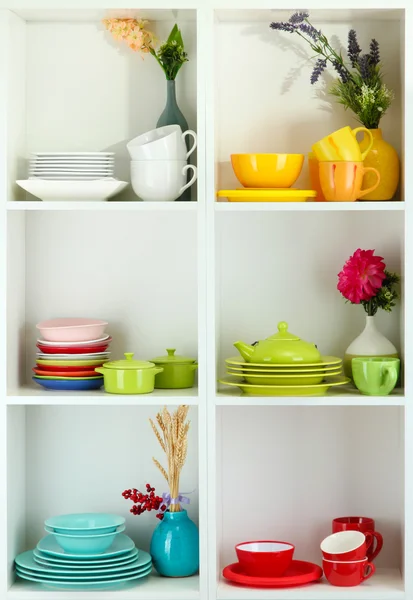 Beautiful white shelves with tableware and deco — Stock Photo, Image