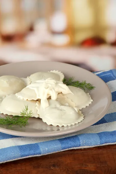 Sabrosos dumplings en plato, sobre mesa de madera —  Fotos de Stock