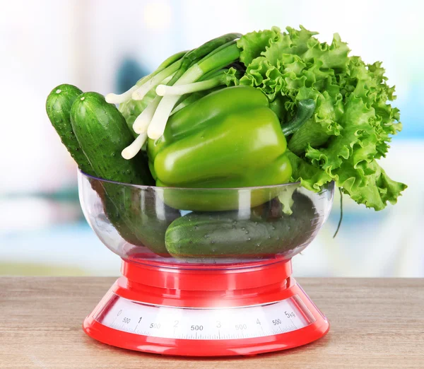 Fresh vegetables in scales on table in kitchen — Stock Photo, Image