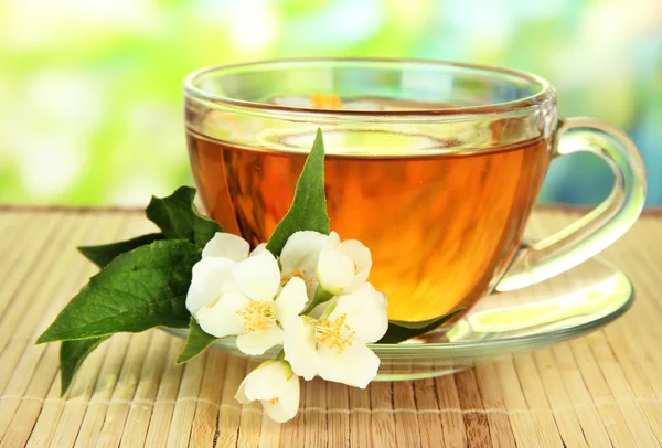 Kopje thee met jasmijn, op bamboe mat, op lichte achtergrond — Stockfoto